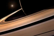 Ilustração mostra os aneis de saturno em perspectiva, onde estão as luas encontradas no novo estudo